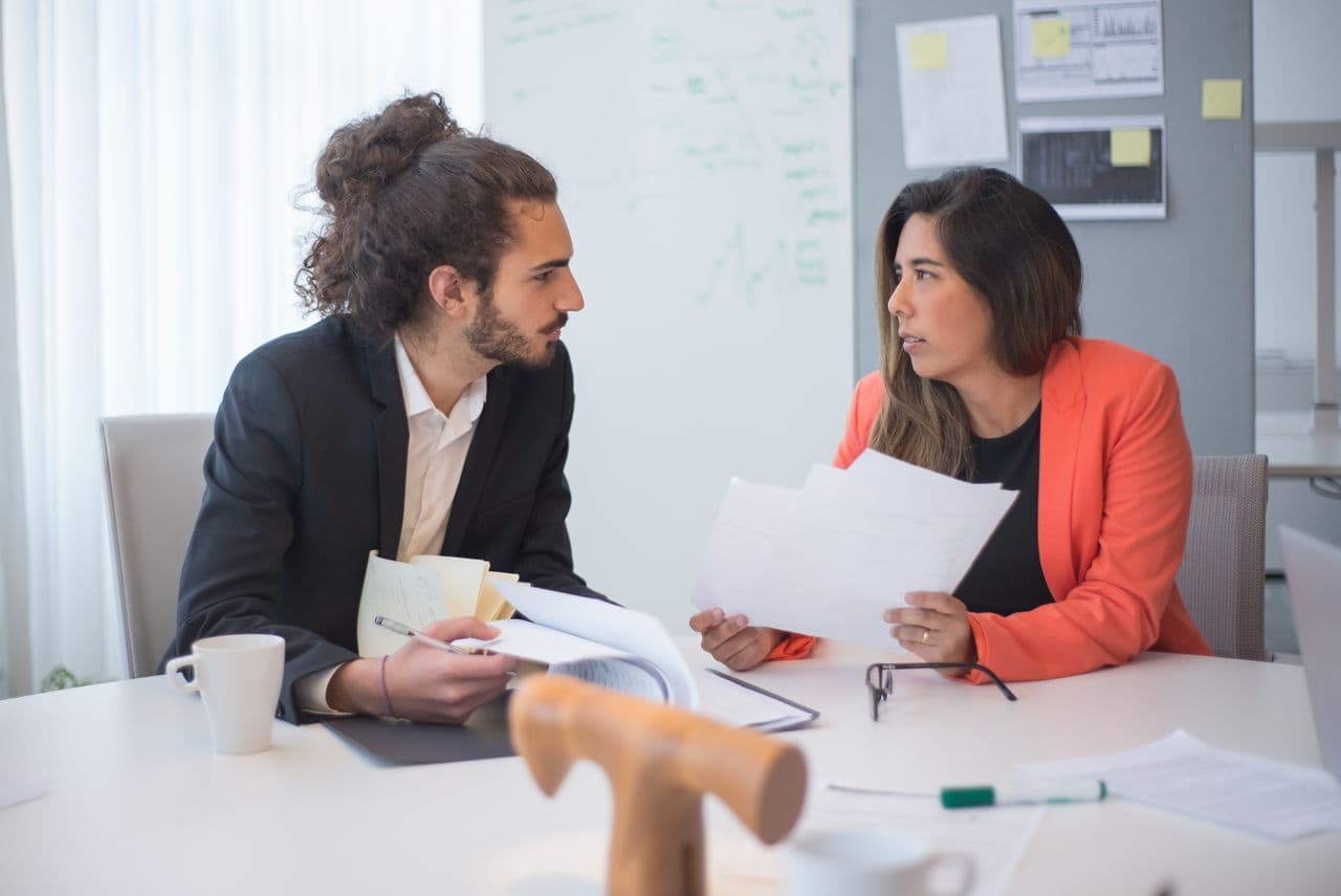 Two colleagues in a focused one-to-one conversation — illustrative stock photo