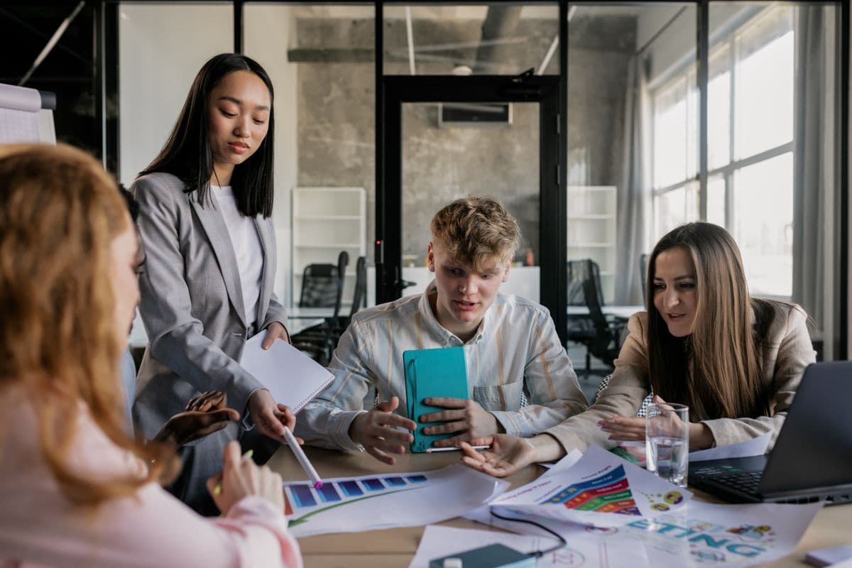 A small group discussing printed material at a table — illustrative stock photo